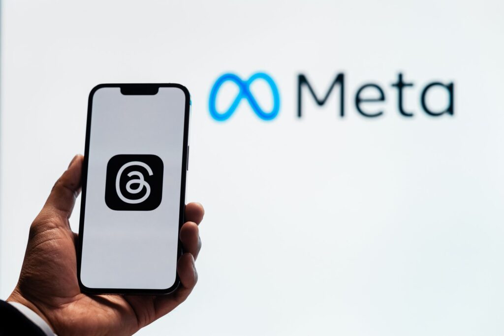 Smartphone tenu devant le logo Meta