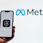 Smartphone tenu devant le logo Meta