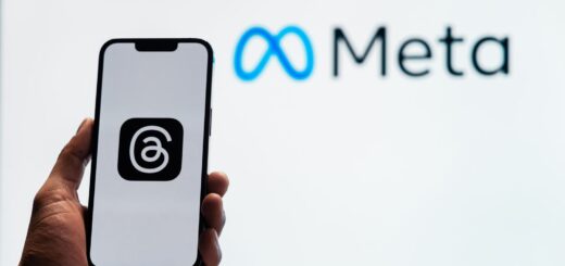Smartphone tenu devant le logo Meta